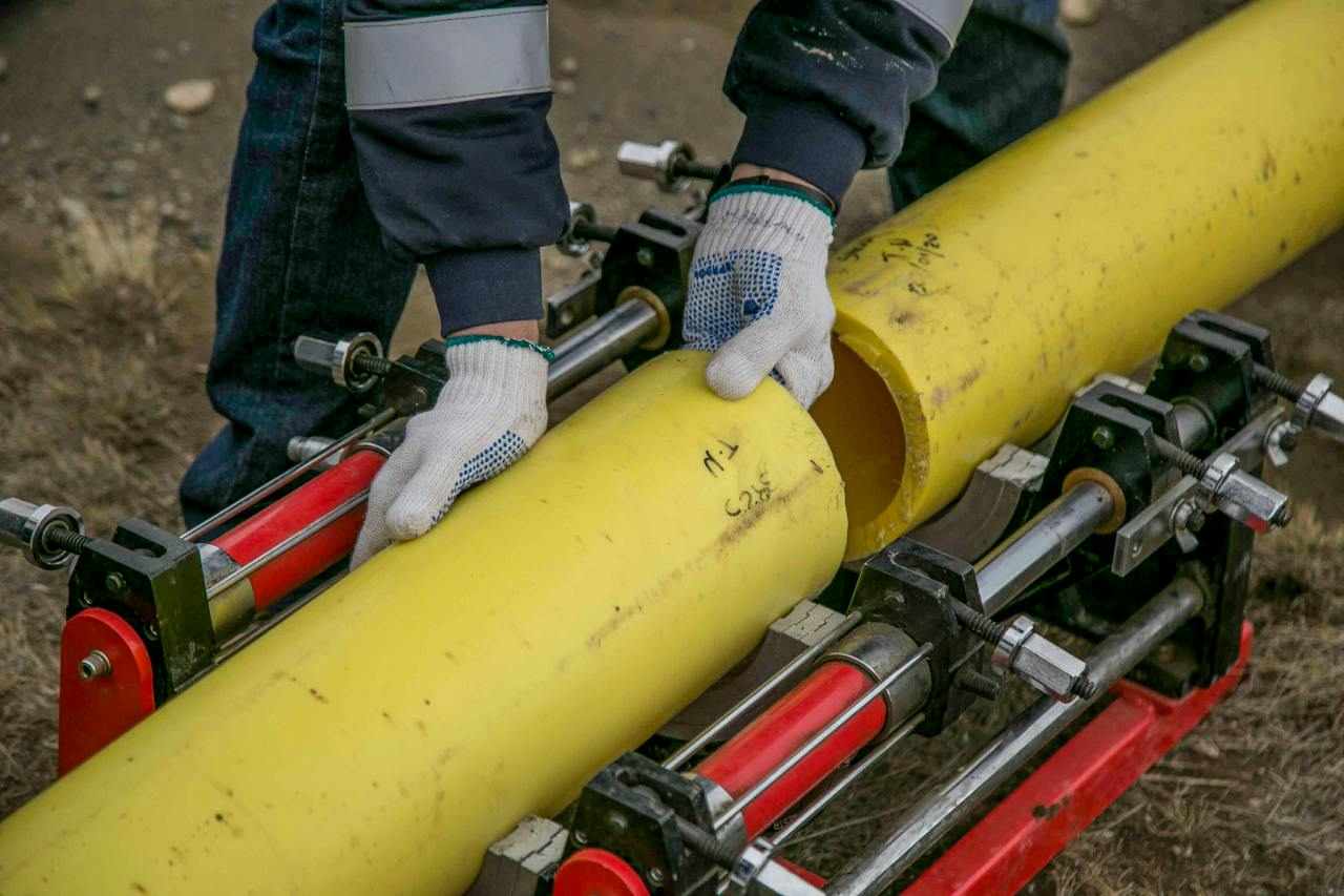 Une personne tenant des grandes tuyaux jaunes